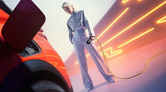 Eine Person steht neben einem Auto in einem futuristisch beleuchteten Raum. Sie hält ein Ladekabel, das mit dem Auto verbunden ist. Der Hintergrund zeigt dynamische, neonfarbene Lichtlinien. Das Auto ist auffällig rot, und die Person trägt helle, moderne Kleidung.